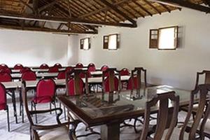 伊塔比里图Hotel Fazenda Caco de Cuia的一间会议室,里面配有桌椅