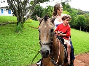 伊塔比里图Hotel Fazenda Caco de Cuia的骑马的女人和孩子