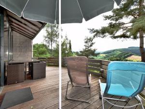 斯塔沃洛Modern Holiday Home in Stavelot with Terrace的露台配有两把椅子和一把遮阳伞,