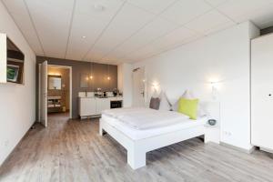莫尔巴赫莫巴赫柏丁公寓式酒店的一间带白色床的卧室和一间厨房