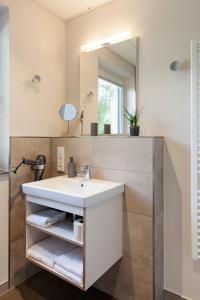 莫尔巴赫莫巴赫柏丁公寓式酒店的一间带水槽和镜子的浴室