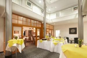 黑尔姆施泰特Best Western Hotel Helmstedt am Lappwald的用餐室配有带黄桌布的桌子