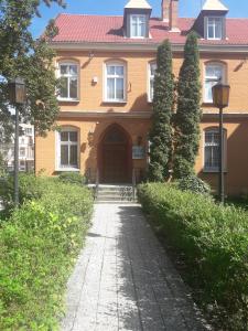 比得哥什Hostel Pałacyk的一座大型橙色房子,前面有走道