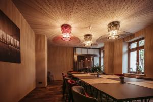开姆尼茨阿历克斯桑德斯酒店寄宿公寓及餐厅的一间会议室,配有桌椅和灯光