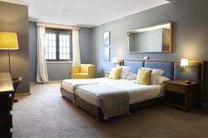 辛特拉舒适辛特拉宾馆的一间卧室配有一张大床和镜子