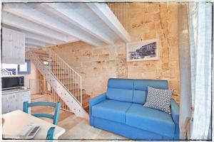 莫诺波利Dimora Barone的客厅设有蓝色沙发,设有楼梯