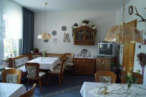 圣安德里斯伯格加格怀特旅馆的一间带桌椅和电视的用餐室