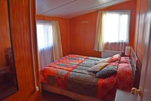 纳塔列斯港卡瓦尼亚斯巴塔哥尼亚英斯图公寓的一间卧室设有一张床和一个窗口