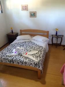 卡内拉Pousada Manu的一间卧室配有一张床,上面有两个娃娃