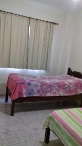 皮乌马Apartamento em Piúma-ES的一间卧室配有一张带紫色毯子的床