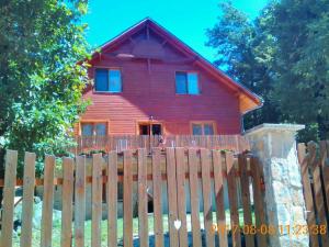 多博戈科Dobogókő vendégház的木制围栏后面的红色房子