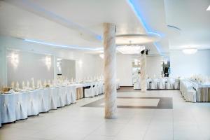 罗兹地区亚历山德鲁夫百利金酒店的宴会厅配有白色的桌子和白色的椅子