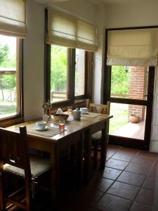 圣罗莎卡拉穆奇塔县Portal del Río Posada的用餐室配有木桌、椅子和窗户