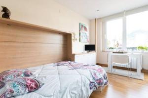 毕尔巴鄂Etxe Ederra的一间卧室配有一张床、一张书桌和一个窗户。