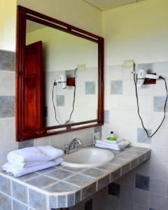 Santa Cruz瓜亚沃酒店的浴室配有盥洗盆、镜子和毛巾
