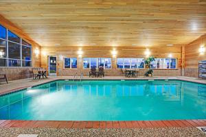罗杰斯Super 8 by Wyndham Rogers Minnesota的一个带木制天花板的大型游泳池
