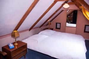 伊尔德帕特斯伍德B&B De Oude Molensteen的卧室配有一张白色的大床和一张桌子