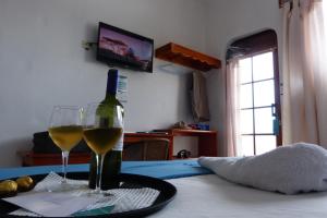 阿约拉港科罗玛加拉帕格斯酒店的桌子上放有一瓶葡萄酒和两杯酒