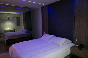 塞蒂拉瓜斯Hauss Excellence Motel的一间卧室配有两张带白色枕头的床