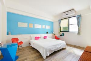 台南Zhizhu Homestay的卧室配有白色床和粉红色枕头