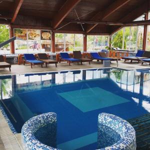 索科矿泉村索科特梅早餐酒店的一个带蓝色桌椅的大型游泳池