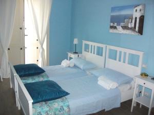 阿杰罗拉Gli dei e le Rose的一间卧室拥有蓝色的墙壁,配有一张带两个枕头的床