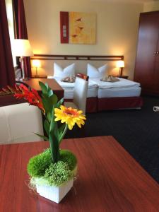 莱比锡施拉加特公寓酒店的一间酒店客房,配有一张带花瓶的桌子