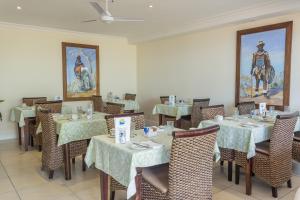 戈登湾蓝色地平线宾馆的一间带桌椅的用餐室和一幅画