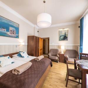 克拉科夫凯赛尔公寓的酒店客房带两张床和一张桌子以及椅子。