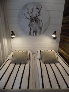 罗瓦涅米苏塔里蒂公寓的卧室配有一张床铺,墙上挂着鹿的照片