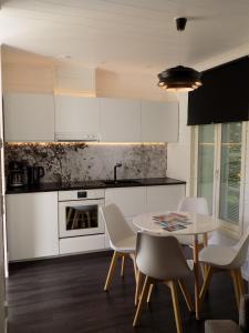 罗瓦涅米苏塔里蒂公寓的厨房配有白色橱柜和桌椅