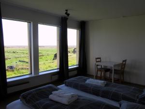 Raudaberg兰达贝格二号乡村民宿的一间卧室设有两张床、一张桌子和窗户。