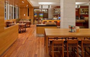 亚特兰大亚特兰大凯悦酒店的餐厅铺有木地板,配有桌椅