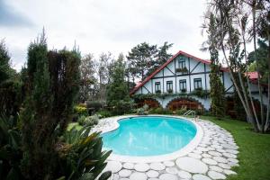 危地马拉Cabaña Suiza的庭院中带游泳池的房子