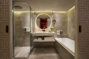 台北台北君悦酒店的一间带水槽、浴缸和镜子的浴室