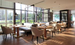 台北台北君悦酒店的餐厅设有桌椅和大窗户。