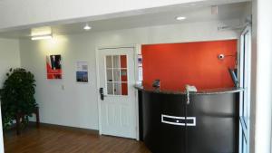 俄克拉何马城俄克拉荷马城剑桥汽车旅馆的一间设有橙色墙壁的柜台的房间
