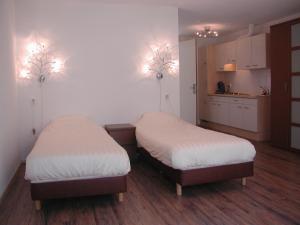 登海尔德Hotel Studio Bosch Duin Strand的带厨房的客房内设有两张单人床。