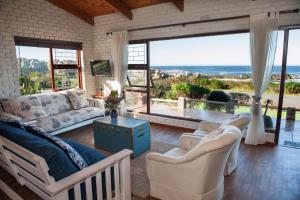 克莱因蒙德La Mer Seafront Selfcatering Accommodation Kleinmond的客厅配有白色家具和大窗户