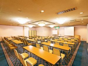 仙台仙台珍珠城市饭店的一间空的讲座室,配有桌椅
