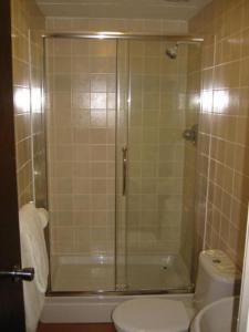 北安普敦朗廷酒店的带淋浴、卫生间和盥洗盆的浴室