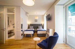 里斯本里斯本白沙别墅豪华公寓的一间设有两张床和一张桌子及椅子的房间
