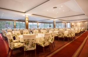 帕莫卡莱莱克斯河温泉酒店的宴会厅配有白色的桌椅