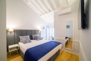 里斯本里斯本白沙别墅豪华公寓的一间卧室配有一张带蓝色毯子的大床