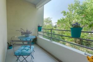 图卢兹Le Jardin Bleu - Dormiratoulouse Basso Cambo的阳台配有桌子和植物窗户。