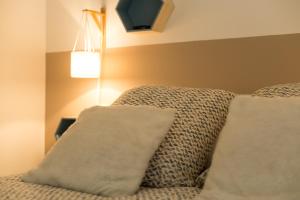 图卢兹Le Jardin Bleu - Dormiratoulouse Basso Cambo的一间卧室配有带两个枕头和一盏灯的床