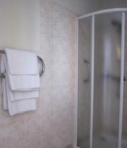 里加威玛加酒店的带淋浴和白色毛巾的浴室