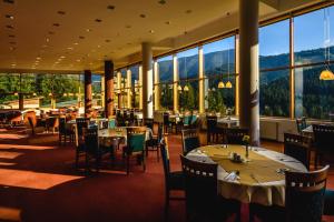 特尔乔夫博波特伊酒店的餐厅设有桌椅和大窗户。