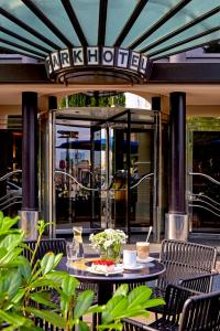 莱比锡莱比锡海滨公园酒店的一个带桌椅的庭院和一座玻璃建筑