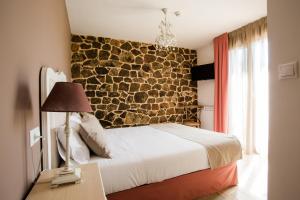 索里亚Casa Rural Pico de los Haces的一间卧室设有石墙和一张床
